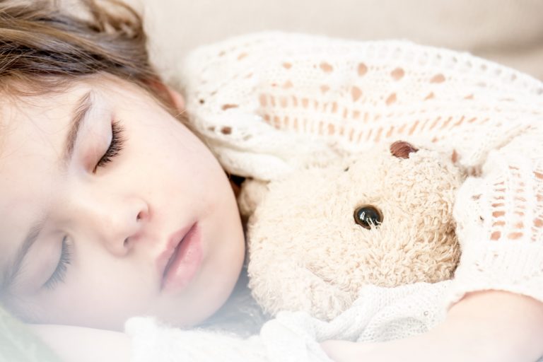 Girl asleep with teddy bear