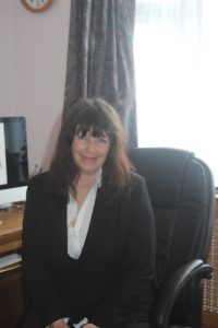 Vicky Tunaley sitting at desk, smiling