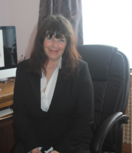 Vicky Tunaley, sitting at desk and smiling